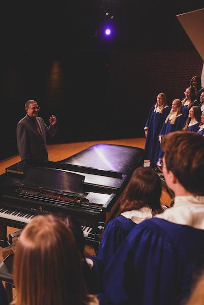 Kurt Runestad directs the choir on stage